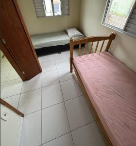 a small room with a bed and a bench at Casa em Mongaguá in Mongaguá