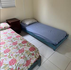 a bedroom with two beds and a nightstand next to at Casa em Mongaguá in Mongaguá