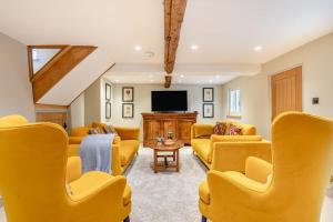 a living room with yellow furniture and a flat screen tv at 3 Bed in Westmancote oc-t30722 in Kemerton