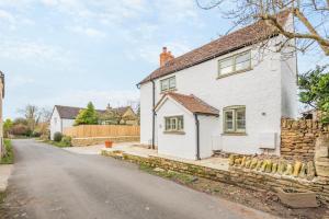 a white house with a stone wall and a street at 3 Bed in Westmancote oc-t30722 in Kemerton