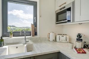 a kitchen with a sink and a microwave and a window at 2 Bed in Newburgh oc-g32594 in Newburgh +23 photos