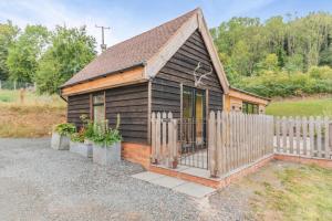 a small wooden cabin with a fence in a yard at 1 Bed in Whitbourne oc-s32935 in Whitbourne