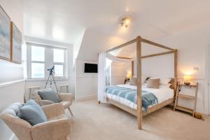 a bedroom with a canopy bed and a chair at 3 Bed in Woolacombe oc-d32422 in Woolacombe
