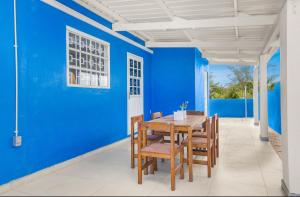 a dining room with blue walls and a table and chairs at The blue wave in Willemstad +19 photos