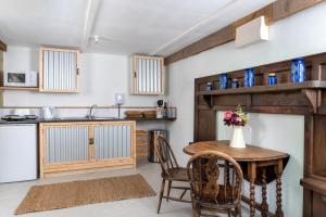 a kitchen with a wooden table and chairs and a counter at 1 Bed in Talybont-on-Usk oc-a29348 in Talybont