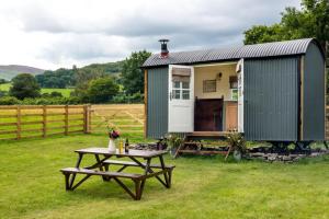 a picnic table in front of a green trailer at 1 Bed in Talybont-on-Usk oc-a29348 in Talybont +8 photos