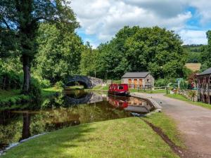 a small boat in a river with a bridge at 1 Bed in Talybont-on-Usk oc-a29348 in Talybont