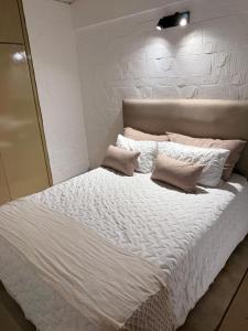 a large white bed with two pillows on it at Portal al mar residence in San Bernardo
