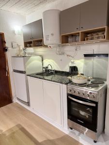 a kitchen with white cabinets and a stove top oven at Portal al mar residence in San Bernardo