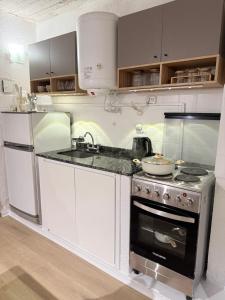 a kitchen with a stove and a sink and a refrigerator at Portal al mar residence in San Bernardo
