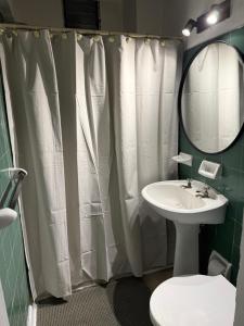 a bathroom with a sink and a shower curtain at Portal al mar residence in San Bernardo