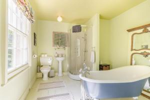 a bathroom with a tub and a toilet and a sink at 4 Bed in Matlock Bath oc-r32432 in Matlock Bank +28 photos