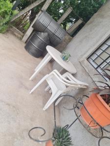 Zwei weiße Gartenstühle stehen auf einer Terrasse in der Unterkunft Dálet in Villa Parque Siquiman