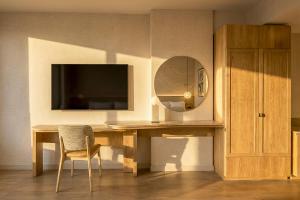 a room with a table with a mirror and a television at Denu Hotel & Spa in Phoenix