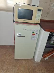 eine Mikrowelle, die auf einem Kühlschrank steht in der Unterkunft Dálet in Villa Parque Siquiman