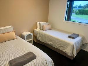 a room with two beds and a window at Brooklyn Views - 4 Bedrooms in Feilding