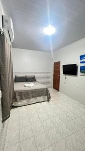 a bedroom with a bed and a flat screen tv at Ilka in Barreirinhas