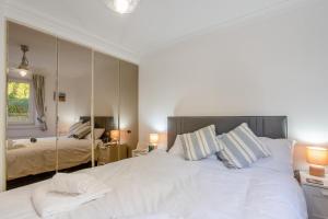 a bedroom with a large white bed and a mirror at 2 Bed in Langland oc-f30206 in Newton