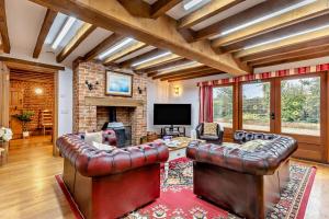 a living room with leather furniture and a fireplace at 4 Bed in Litcham oc-h30106 in Litcham