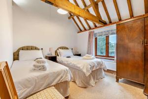 two twin beds in a room with a window at 4 Bed in Litcham oc-h30106 in Litcham +28 photos