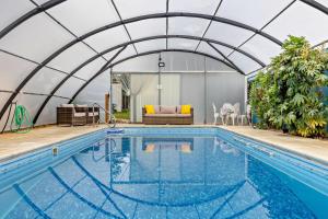 a swimming pool in a greenhouse next to a house at 4 Bed in Litcham oc-h30106 in Litcham