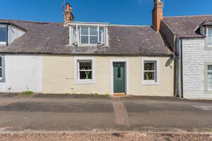 an old house with a green door on a street at 3 Bed in Coldingham oc-b29846 in Coldingham