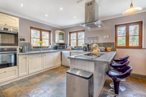 a large kitchen with white cabinets and a purple stool at 5 Bed in Ystrad Meurig oc-r31133 in Ystrad Meurig