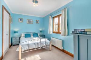 a blue bedroom with a bed and a window at 5 Bed in Ystrad Meurig oc-r31133 in Ystrad Meurig