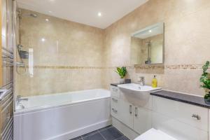 a bathroom with a white tub and a sink and a bath tubermott at 2 Bed in West Quantoxhead oc-p30893 in West Quantoxhead +9 photos