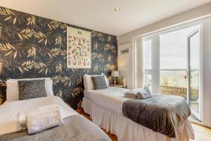 a bedroom with two beds and a large window at 2 Bed in West Quantoxhead oc-p30893 in West Quantoxhead