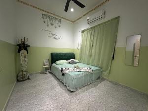 a bedroom with a bed in the corner of the room at Olive Cottage in Marang