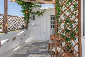 a balcony with a pergola and a table and chairs at Casa de Flores 1 in Plaka Milou