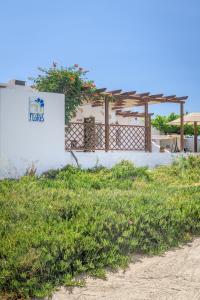 a white building with a sign on the side of it at Casa de Flores 1 in Plaka Milou
