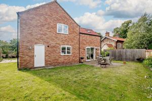 a brick house with a picnic table in a yard at 3 Bed in Syderstone oc-a27669 in Syderstone