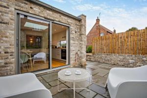 a patio with white chairs and a table at 1 Bed in Syderstone oc-c29233 in Syderstone
