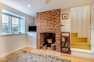a brick fireplace in a living room with a book shelf at 1 Bed in Syderstone oc-c29233 in Syderstone