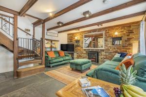 a living room with green furniture and a stone wall at 3 Bed in Padstow oc-h28928 in Padstow