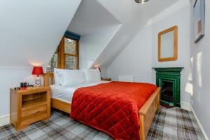 a bedroom with a bed with a red blanket at 3 Bed in Huntly oc-g31733 in Huntly