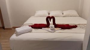 a bed with a red item on top of it at Casa Excalibur in Máncora