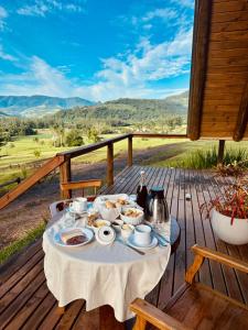 a table with a plate of food on a deck at Maria Rita dos Canyons in Praia Grande