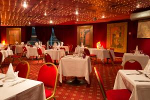 une salle à manger avec des tables blanches et des chaises rouges dans l'établissement Espace Leonard De Vinci, à Lisses