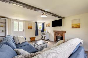 a living room with a blue couch and a fireplace at 3 Bed in Stowupland oc-p32216 in Stowmarket
