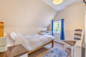 a bedroom with a bed and a chair and a window at 3 Bed in Stowupland oc-p32216 in Stowmarket