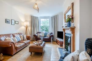a living room with leather couches and a fireplace at 3 Bed in Southwold oc-rvil in Southwold