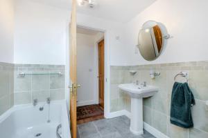 a bathroom with a tub and a sink and a mirror at 5 Bed in St. Bees oc-w32446 in St Bees +25 photos
