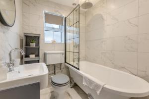 a white bathroom with a tub and a toilet and a sink at 6 Bed in Buxton oc-s31063 in Buxton +20 photos