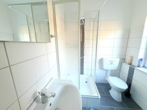 a bathroom with a sink and a toilet and a tub at Haus Waldblick - Natur pur am Rande des Nationalparks Jasmund in Sassnitz +14 photos