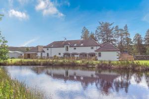 a house with a river in front of it at 2 Bed in Newtonmore oc-e32418 in Newtonmore