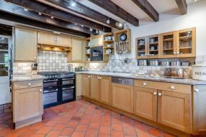 a large kitchen with wooden cabinets and appliances at 7 Bed in Talgarth oc-h30349 in Talgarth