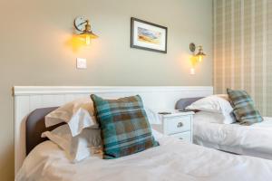 a hotel room with two beds and a night stand at 2 Bed in Newtonmore oc-e32418 in Newtonmore